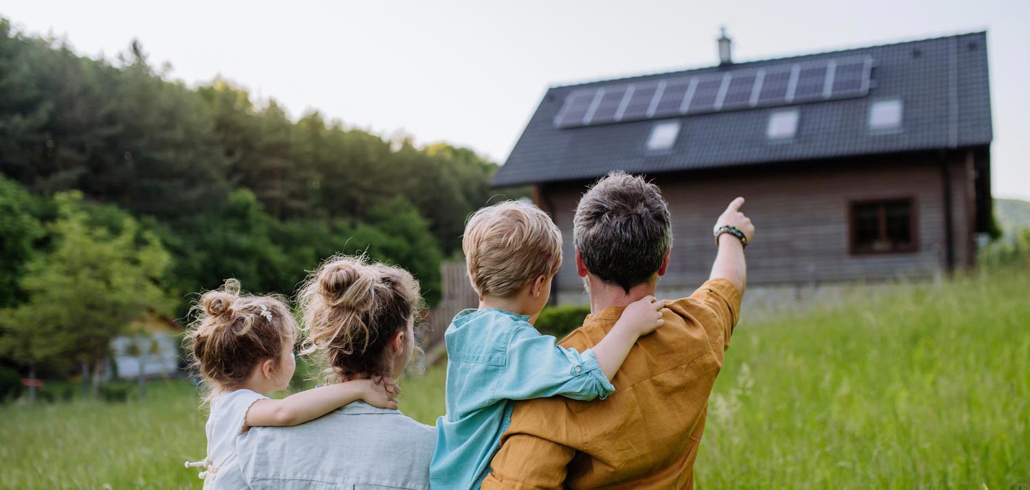 prime autoconsommation famille pointant maison avec panneaux solaires photovoltaiques